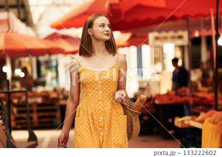 Walking around. Young woman is on the vegetable market or bazaar Walking around. Young woman is on the vegetable market or bazaar 133222602