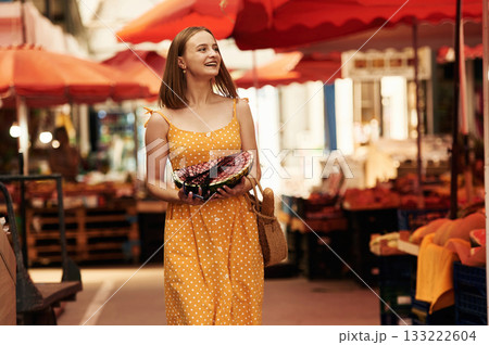 Walking around. Young woman is on the vegetable market or bazaar Walking around. Young woman is on the vegetable market or bazaar 133222604