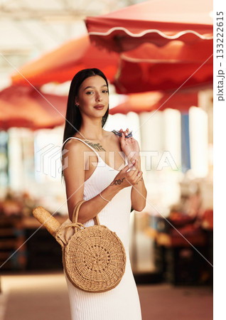 Standing and posing. Young woman is on the vegetable market or bazaar 133222615
