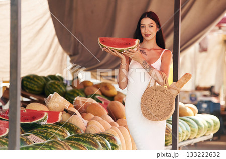 Tattooed young woman is on the vegetable market or bazaar Tattooed young woman is on the vegetable market or bazaar 133222632
