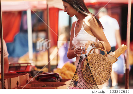 Tattooed young woman is on the vegetable market or bazaar 133222633