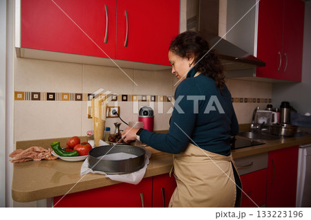 Woman Cooking in Red Kitchen With Apron Preparing Ingredients and Fresh Vegetables 133223196
