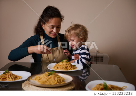 Mother And Child Share A Cozy Pasta Meal At The Table In A Warm Home Setting Mother And Child Share A Cozy Pasta Meal At The Table In A Warm Home Setting 133223238