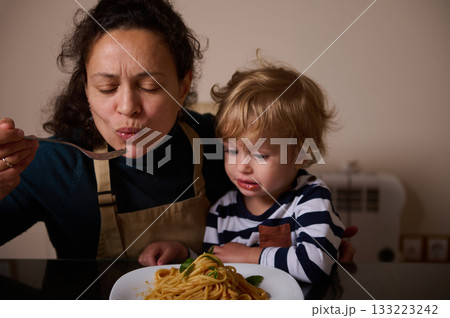 Mother And Child Enjoy Spaghetti Dinner At Home, A Tender Family Moment Mother And Child Enjoy Spaghetti Dinner At Home, A Tender Family Moment 133223242