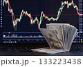 Stack of hundred-dollar bills against a crypto exchange chart. 133223438