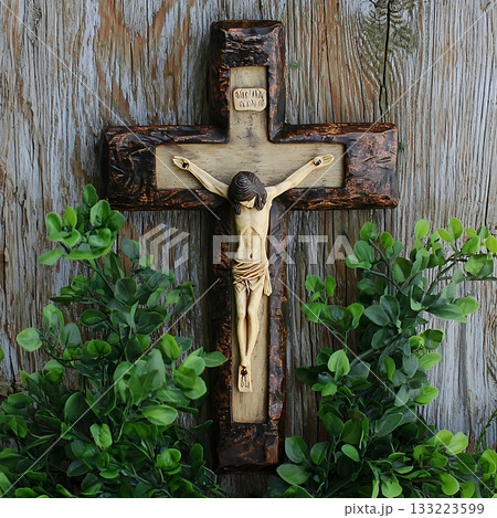 Wooden cross with a man on it, Jesus Christ, is displayed on a wooden wall 133223599