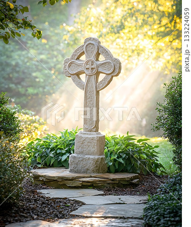 Large stone cross is in a garden with green plants 133224059