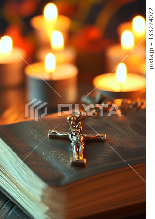Book with a cross on it and candles on top of it Book with a cross on it and candles on top of it 133224072