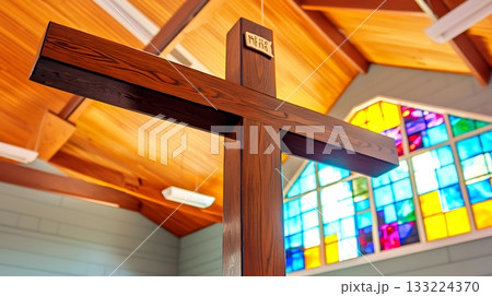Wooden cross is suspended from the ceiling of a church Wooden cross is suspended from the ceiling of a church 133224370