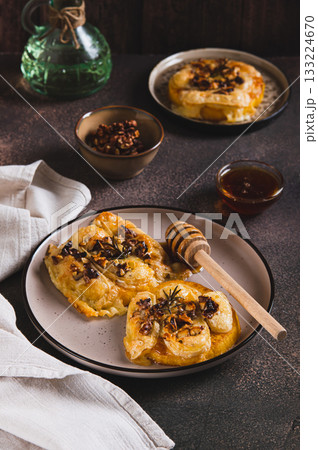 Pumpkin, cheese, nuts and rosemary baked with honey topping on a plate on the table vertical view Pumpkin, cheese, nuts and rosemary baked with honey topping on a plate on the table vertical view 133224670