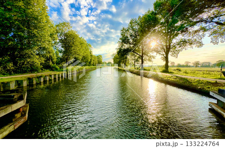 Enjoy the Beauty of a Serene River Landscape Surrounded by Lush Greenery and Its Reflection 133224764