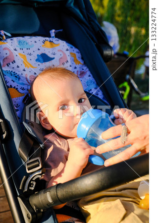 Baby in Stroller with Sippy Cup Outdoors Baby in Stroller with Sippy Cup Outdoors 133224774