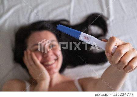 Surprised Woman with Positive Pregnancy Test Surprised Woman with Positive Pregnancy Test 133224777