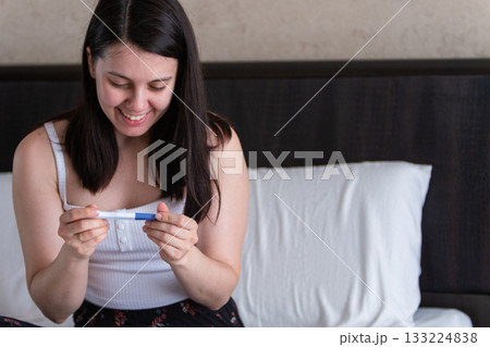 Surprised Woman with Positive Pregnancy Test 133224838