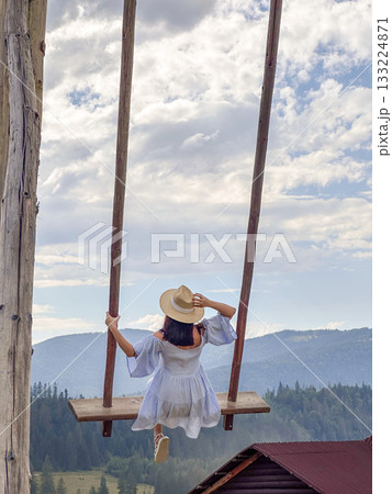 Woman Swinging Over Scenic Mountain Landscape 133224871