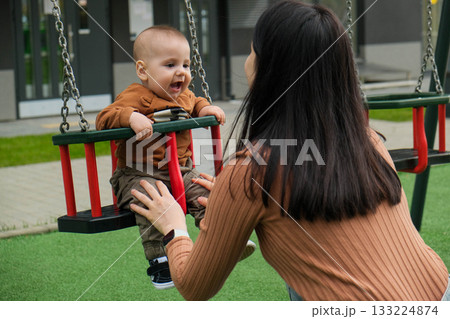 Mother and Baby on Swing in Playground 133224874