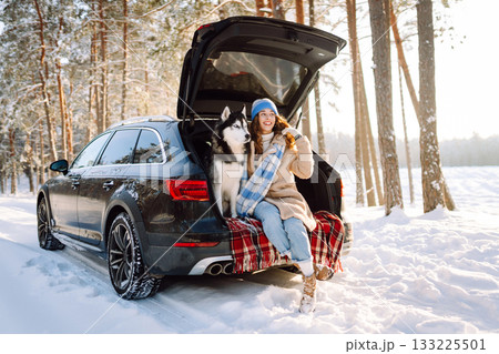 Woman with husky dog have picnic in car trunk near pine forest, traveling by car. Travel concept. 133225501