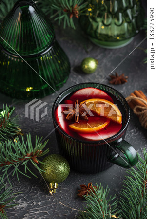 Holiday Mulled Wine with Orange and Apple in Green Mug Surrounded by Christmas Decor Holiday Mulled Wine with Orange and Apple in Green Mug Surrounded by Christmas Decor 133225990