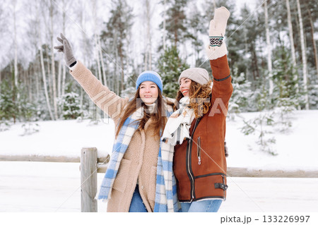 Happy friends having fun playing in winter park. Friends communicate and enjoying nature. 133226997