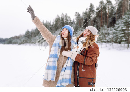 Happy friends having fun playing in winter park. Friends communicate and enjoying nature. 133226998