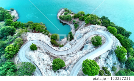 Winding Hiking Trail Along Serene Water in a Lush Green Landscape With Clear Skies 133227231