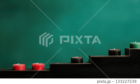 Geometric Arrangement of Red, Black, and Green Candles on a Wooden Step Against a Teal Background Geometric Arrangement of Red, Black, and Green Candles on a Wooden Step Against a Teal Background 133227239