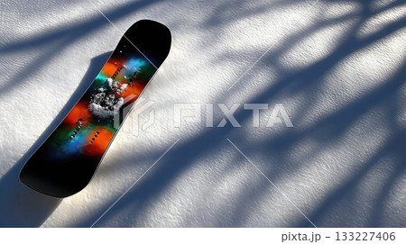 Snowboard Resting on Snowy Ground With Shadows Creating Patterns on the Surface 133227406