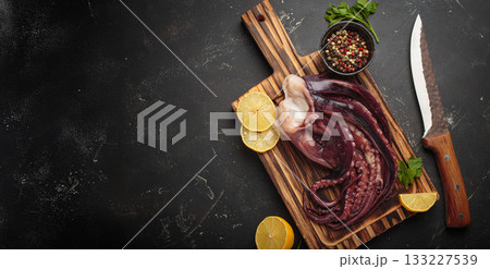 Raw squid octopus wooden cutting board knife gourmet seafood lemon pepper preparing copy space Raw squid octopus wooden cutting board knife gourmet seafood lemon pepper preparing copy space 133227539