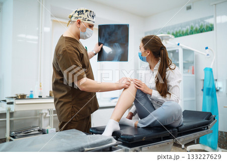 Doctor examines x-ray of patient leg. Foot and sprain concept. Sport exercise injuries. Doctor examines x-ray of patient leg. Foot and sprain concept. Sport exercise injuries. 133227629