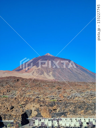 A Majestic Mountain Peak Stands Proudly Against a Clear Blue Sky, Showcasing Natures Beauty A Majestic Mountain Peak Stands Proudly Against a Clear Blue Sky, Showcasing Natures Beauty 133227745