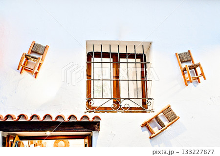 Rustic window with decorative chairs against a white wall. Altea, Alicante 133227877