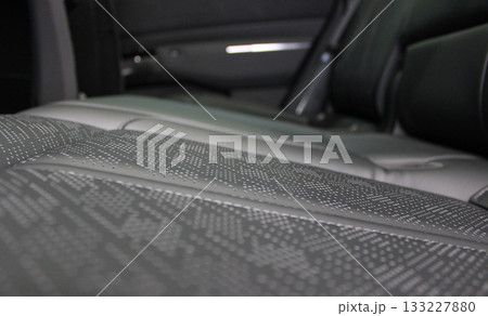 Detailed angle view of the perforations on the artificial leather of the rear car heated seats  133227880
