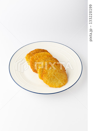 Ukrainian deruny , crispy potato pancakes stacked on a plate, isolated on white 133228199