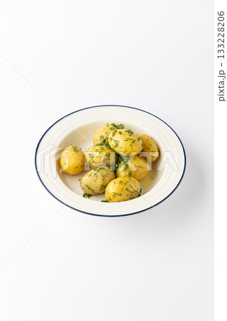Boiled baby potatoes with butter and fresh dill in bowl, isolated on white background 133228206