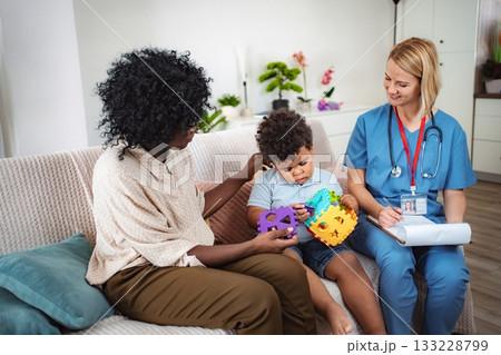 Nurse measuring child temperature at home 133228799