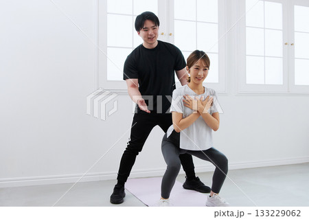 パーソナルトレーナーにトレーニングを受ける若い女性 133229062