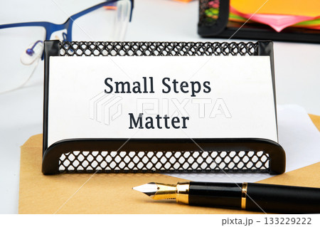 A motivational sign stating Small Steps Matter is featured on a desk alongside a pen and glasses, capturing the essence of taking gradual steps towards success and change A motivational sign stating Small Steps Matter is featured on a desk alongside a pen and glasses, capturing the essence of taking gradual steps towards success and change 133229222