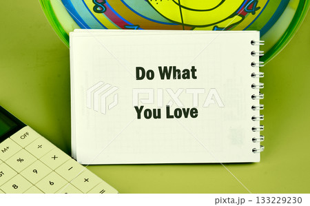 A notepad with the phrase Do What You Love sits on a desk alongside a calculator and a colorful spiral design. This setup encourages creativity and productivity during work hours A notepad with the phrase Do What You Love sits on a desk alongside a calculator and a colorful spiral design. This setup encourages creativity and productivity during work hours 133229230
