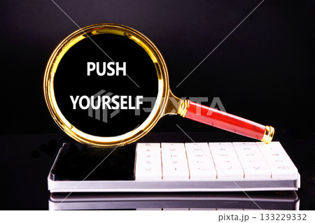 A bright golden magnifying glass highlights the phrase PUSH YOURSELF on a sleek white surface, inspiring determination and focus in a simple, clean workspace A bright golden magnifying glass highlights the phrase PUSH YOURSELF on a sleek white surface, inspiring determination and focus in a simple, clean workspace 133229332