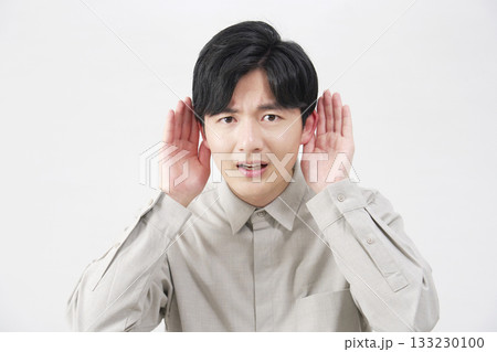 男性 耳に手を当てて聴く 20代 白背景 男性 耳に手を当てて聴く 20代 白背景 133230100
