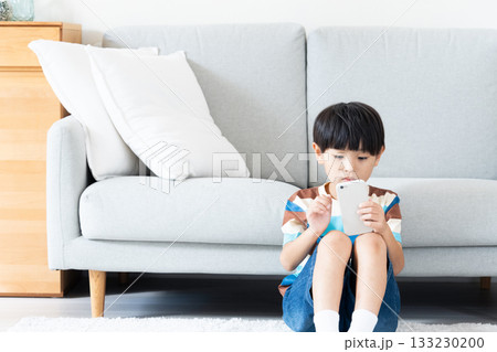 リビングでスマホで遊ぶ小学生男子 133230200