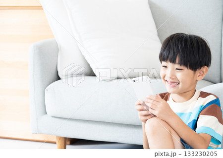 リビングでスマホで遊ぶ小学生男子 133230205