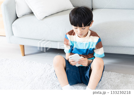 リビングでスマホで遊ぶ小学生男子 133230218