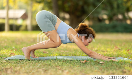 Different yoga poses performed by a slender woman in summer garden Different yoga poses performed by a slender woman in summer garden 133231664