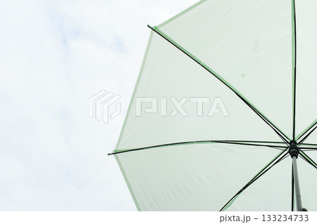 open green umbrella in rainy day with white cloud and blue sky open green umbrella in rainy day with white cloud and blue sky 133234733