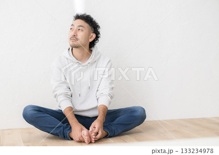 床に座るカジュアルな服装の髭の男性の全身 133234978