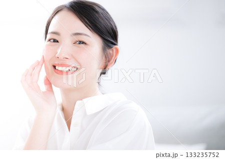 白シャツで清潔感あふれる若い女性の笑顔とスキンケア・美肌の美容ビューティー クローズアップカメラ目線 白シャツで清潔感あふれる若い女性の笑顔とスキンケア・美肌の美容ビューティー クローズアップカメラ目線 133235752