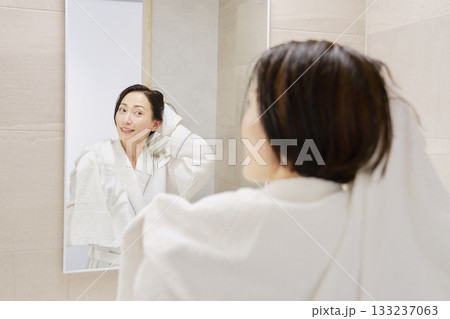 お風呂上がりに濡れている髪をバスタオルで拭く女性 お風呂上がりに濡れている髪をバスタオルで拭く女性 133237063