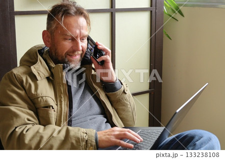 Smiling man working on laptop indoors 133238108