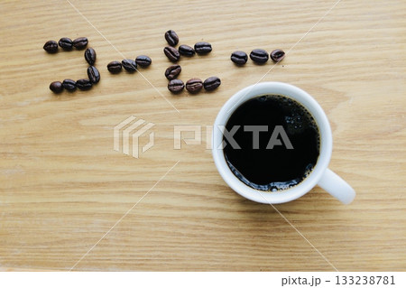 テーブルの上に置かれたコーヒー豆とコーヒー 133238781